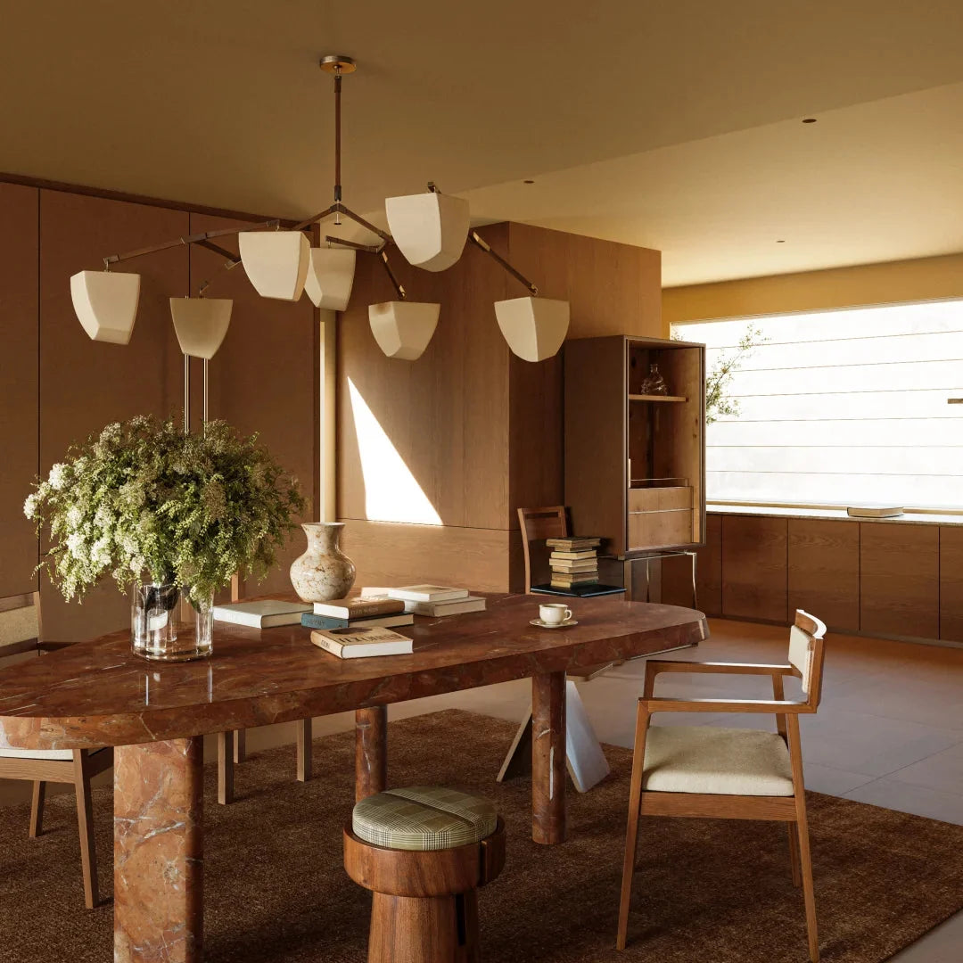 Brass branching chandelier with frosted white shades over large dining table