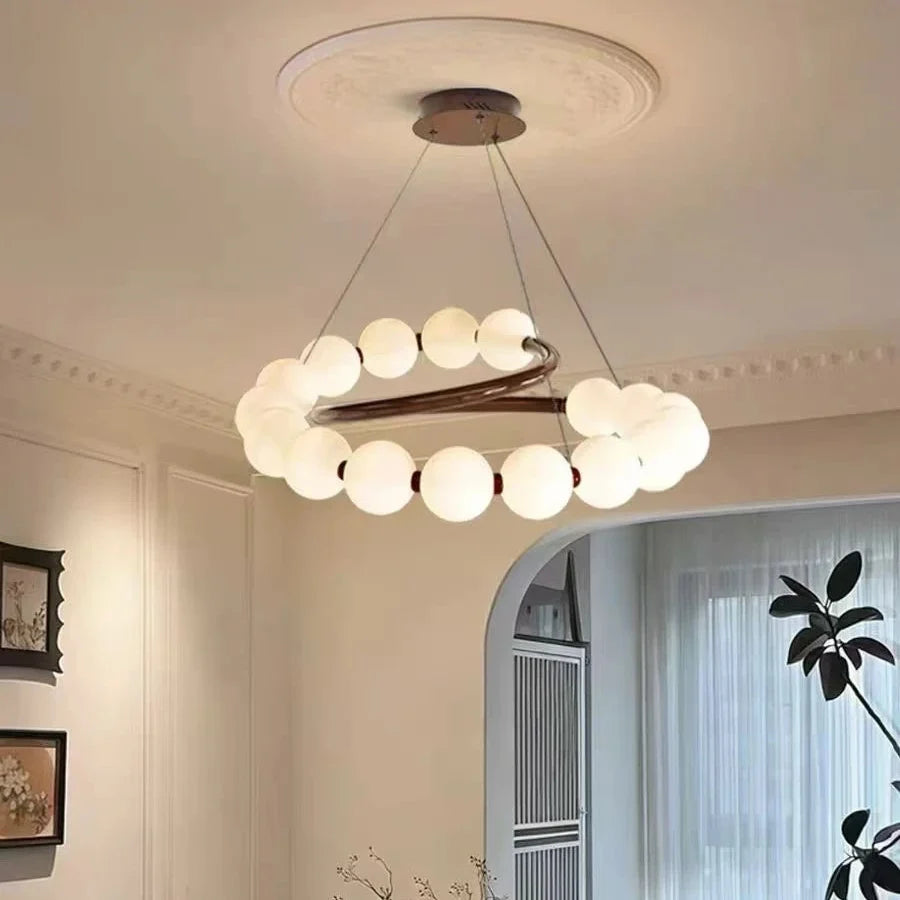 Pearl spiral chandelier featuring white globe shades and a dark wood crossbar