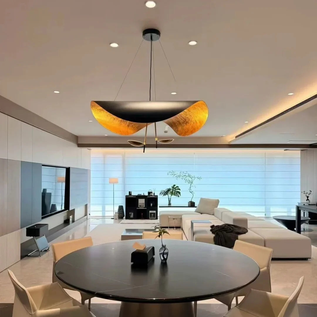 Black and gold foil disc pendant light centered over a room ceiling