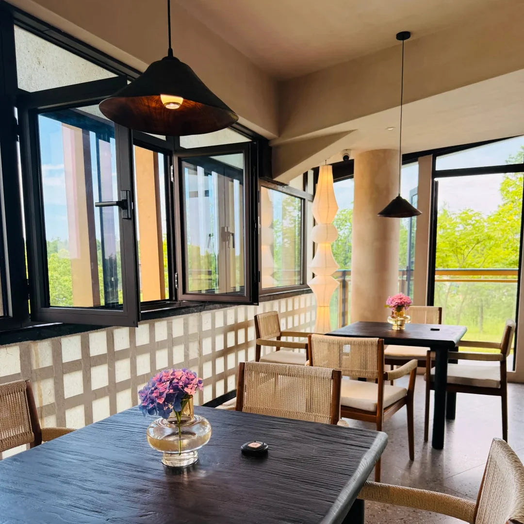 Cone wood pendant light with dark wood shade glowing warm light above dining table
