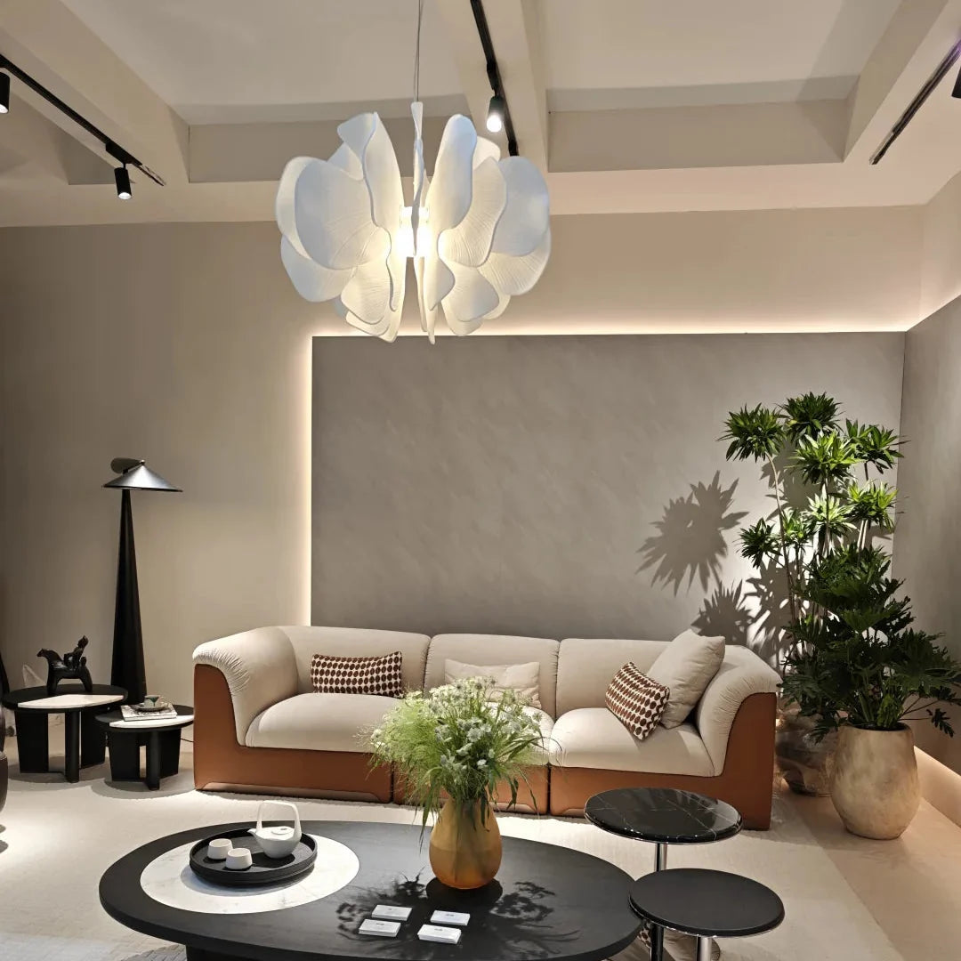 Ceramic petal chandelier with white petal shades hanging above a living room seating area