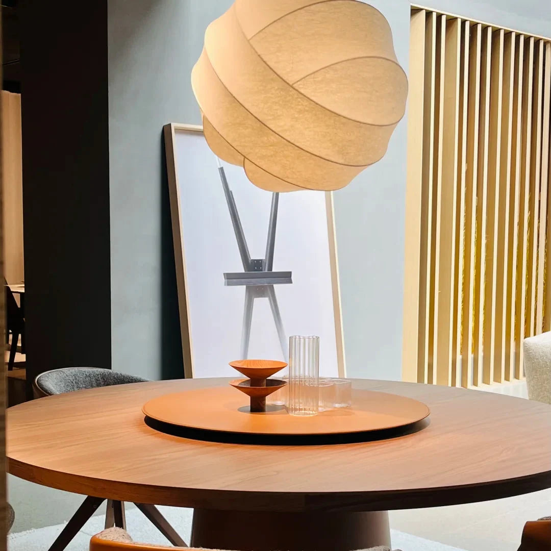 Luma silk pendant light with beige pleated fabric shade suspended over a table