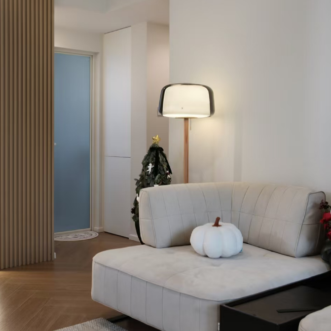 Smoked-glass floor lamp with wood pole on a black base in a living room