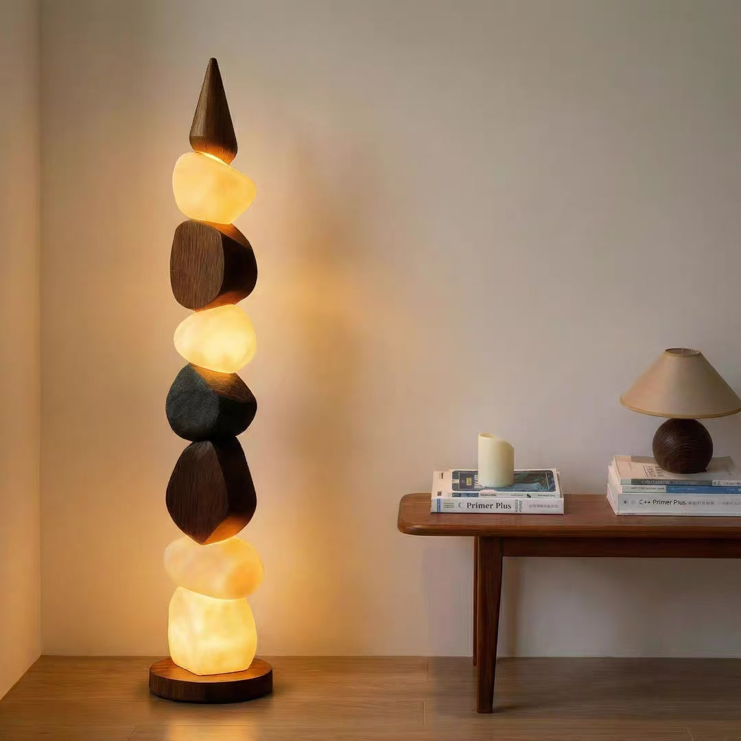 Stacked pebble floor lamp with warm glowing stone shades and circular wooden base