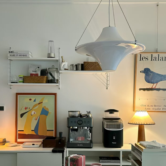 White pendant disc light with curved shade and hanging cords
