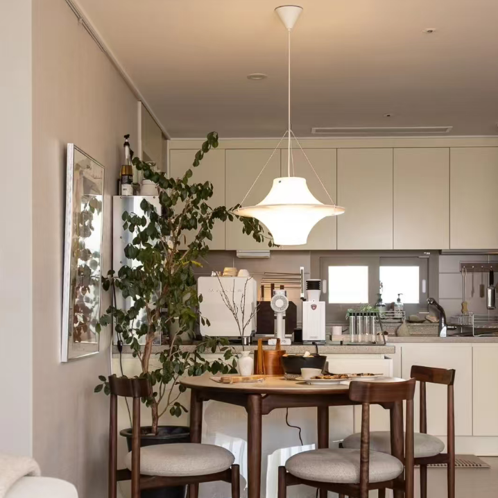 Star-shaped white disc pendant light hanging above dining table