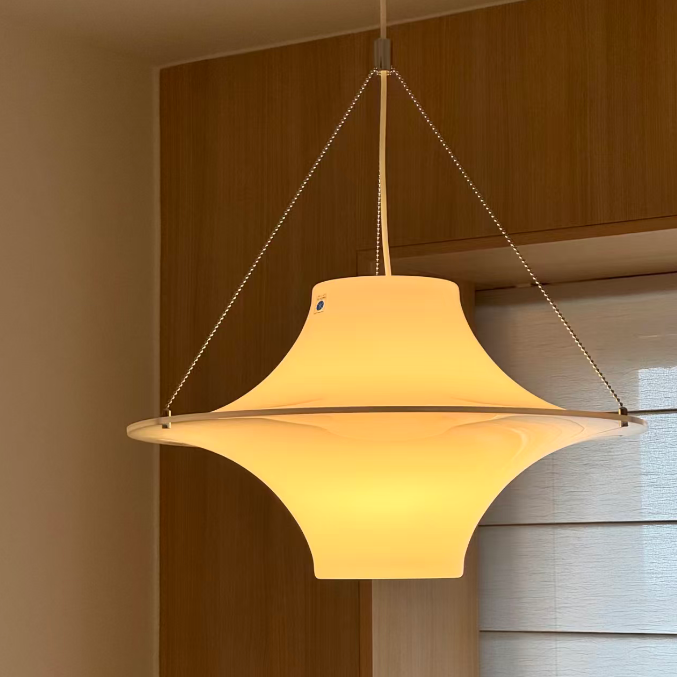Cream-toned disc pendant light with dangling cords and central mounting cap