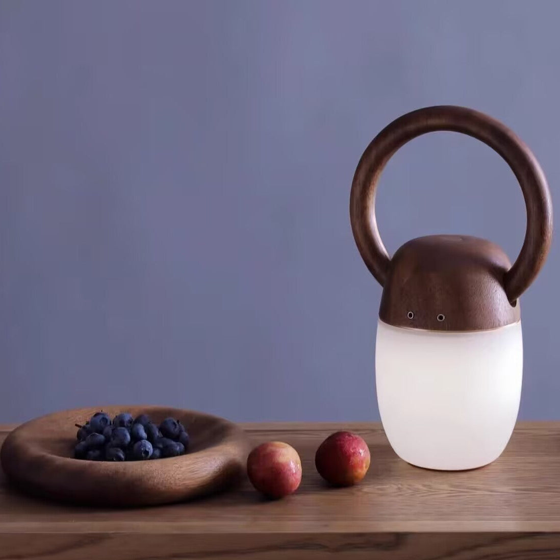 Dark wood ring-handle lantern with white frosted glass shade on tabletop