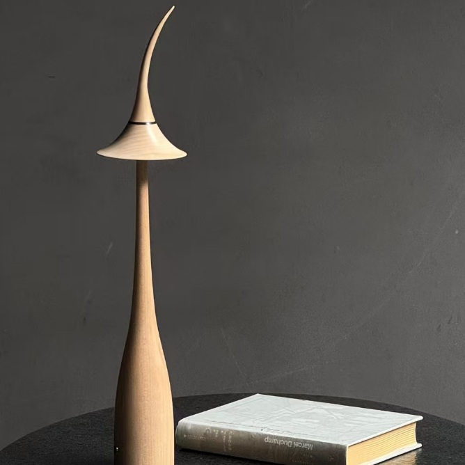 Maple wood cordless table lamp with black curved shade and warm light glow.