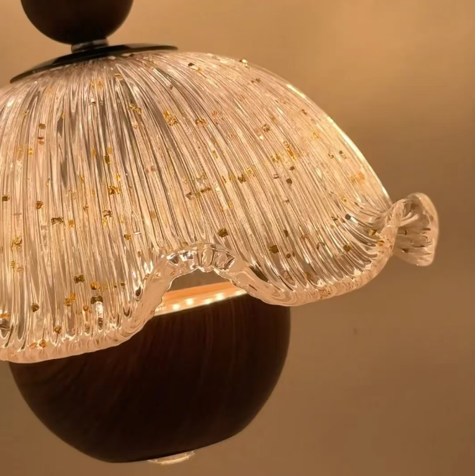 Close-up of Fleur ruffle pendant light: frosted ribbed glass shade with gold flecks