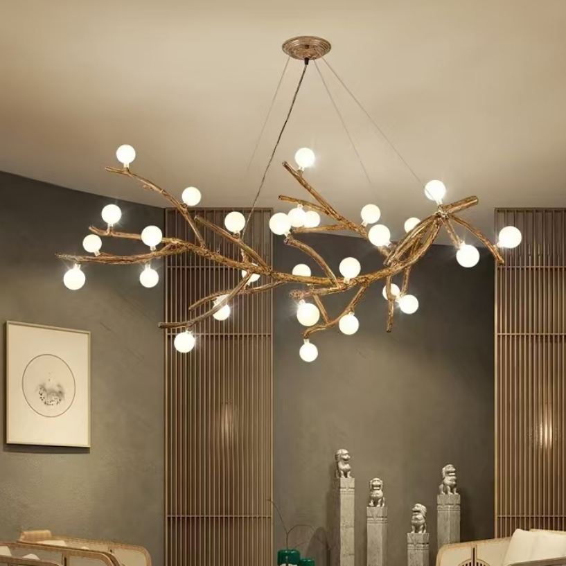 Gold branch chandelier with glowing round globe bulbs suspended from ceiling.