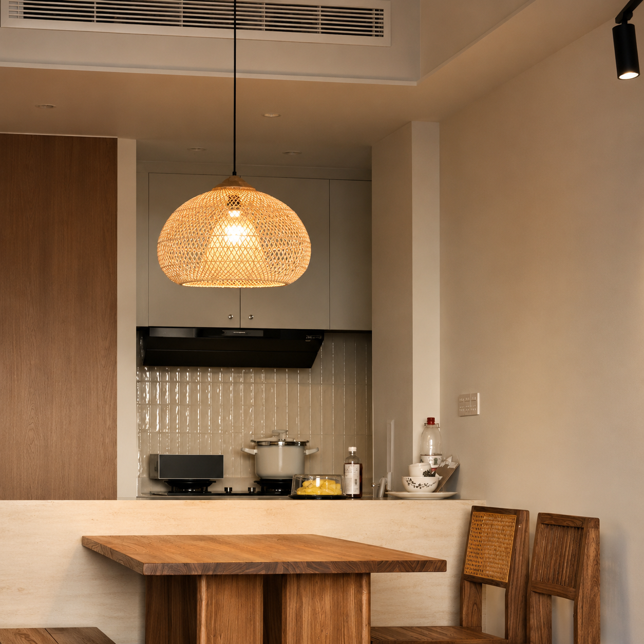 Tan rattan pendant light with woven dome shade over a kitchen island counter.