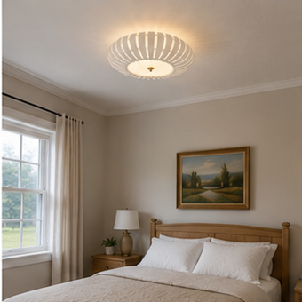 Ribbed flush mount ceiling light glowing above a bed in a bedroom