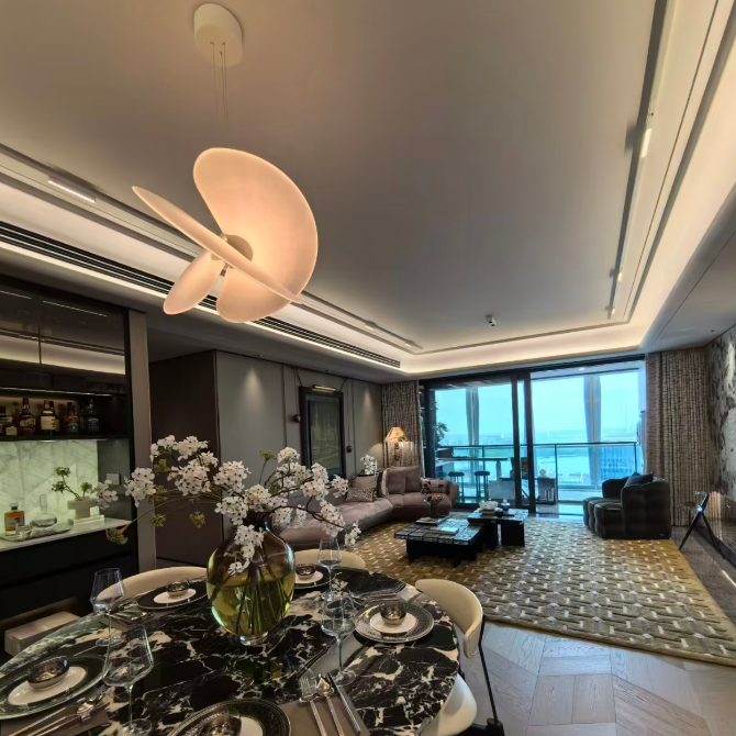 Butterfly pendant light with white dome shade and crossed blades near a window seating area