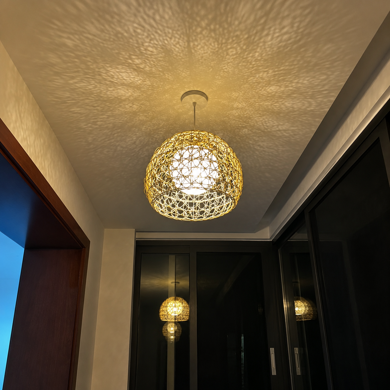 Rattan orb pendant light with woven sphere shade, hanging from ceiling fixture