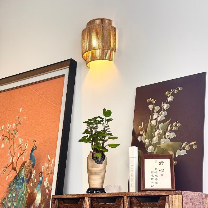 Woven rope drum wall sconce with warm amber light and cylindrical ribbed shade