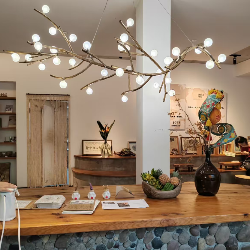 Gold branch chandelier featuring curved arms and white globe bulbs suspended from a round canopy