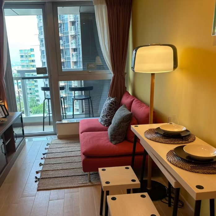 Floor lamp with smoked glass shade and wood pole, standing next to a couch