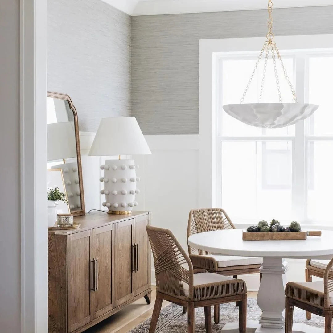 Petal-shaped chandelier with white shade and gold-tone chain above seating area