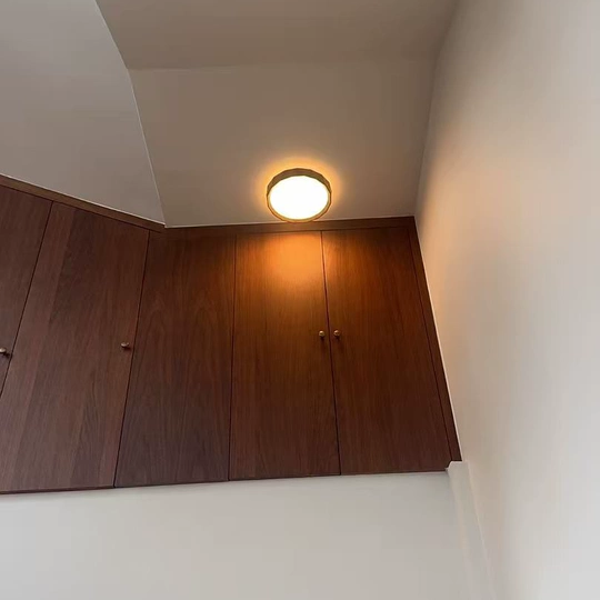 Walnut wood flush mount ceiling light with warm lit round diffuser