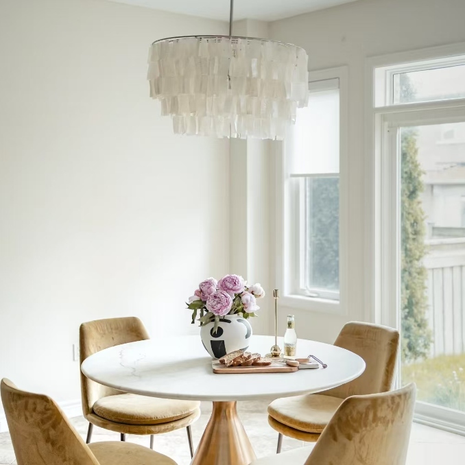 White capiz shell tiered chandelier above round dining table