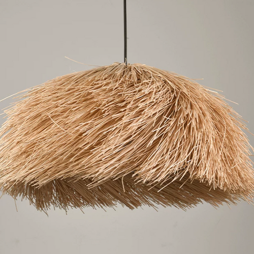 Thatched straw pendant light with warm golden shade and thin black hanging rod