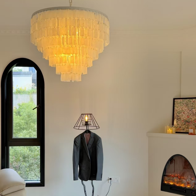 Warm-lit tiered capiz shell chandelier with chrome ceiling mount