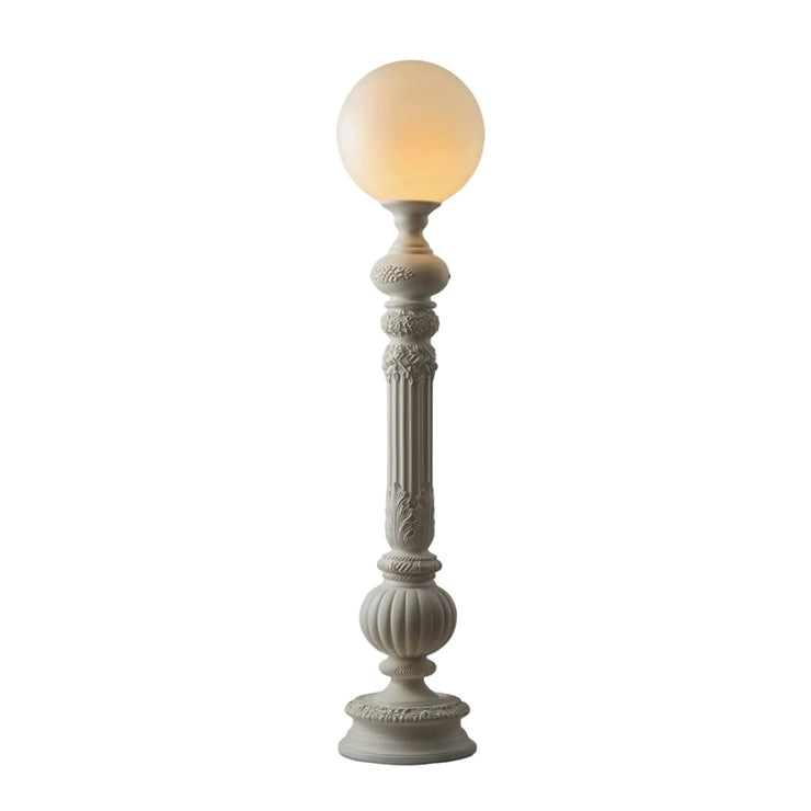 White floor lamp with round globe shade and carved pedestal base
