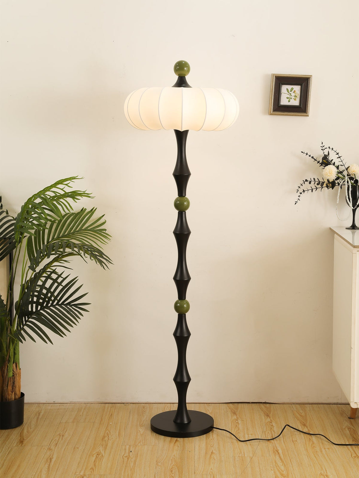 Tall floor lamp with cream ribbed drum shade and black pillar-like base