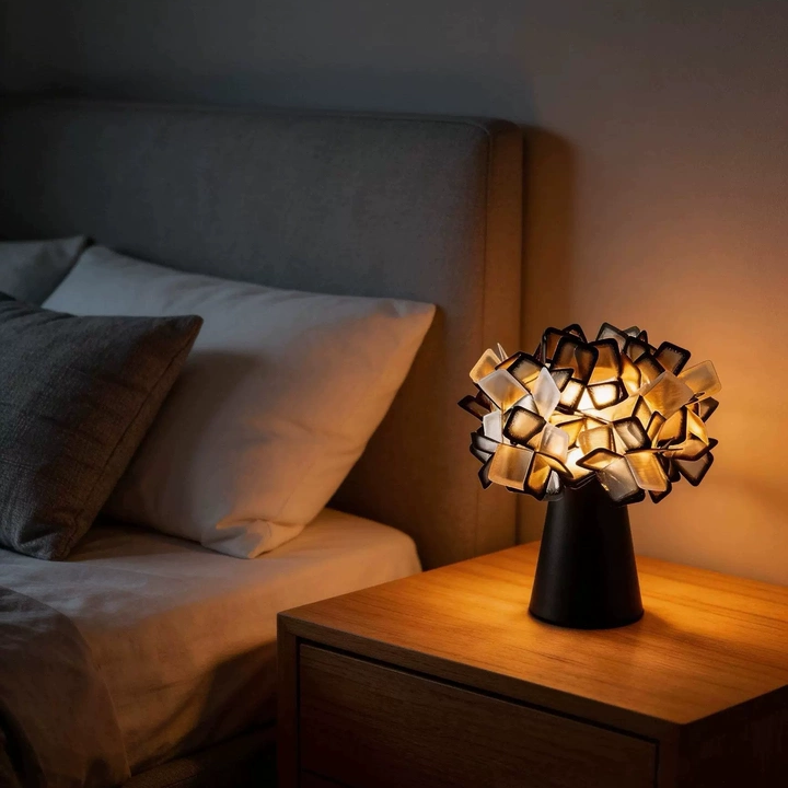 Geometric blossom table lamp with black base and warm white geometric cube light.
