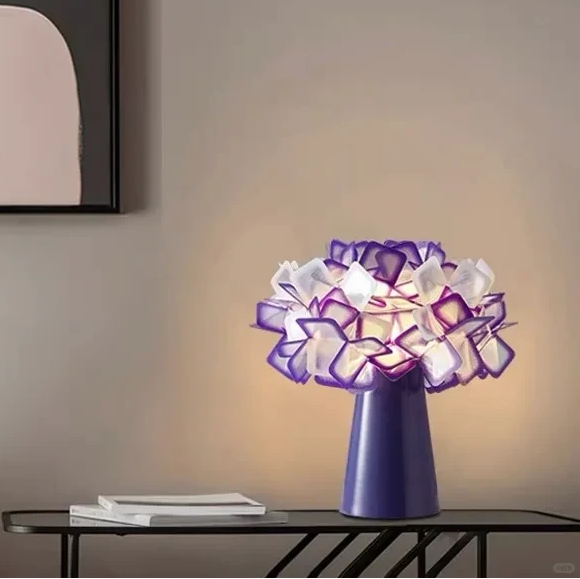 Geometric blossom table lamp with purple base and purple-and-white glowing cube shade.