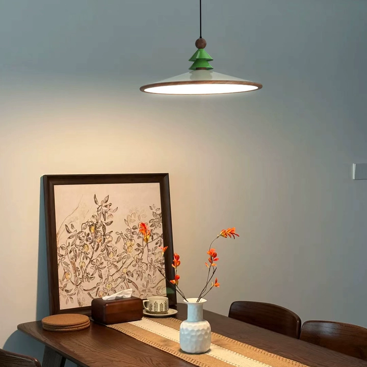 Green cone pine pendant light with brass trim ring shade and brown mounting knob.