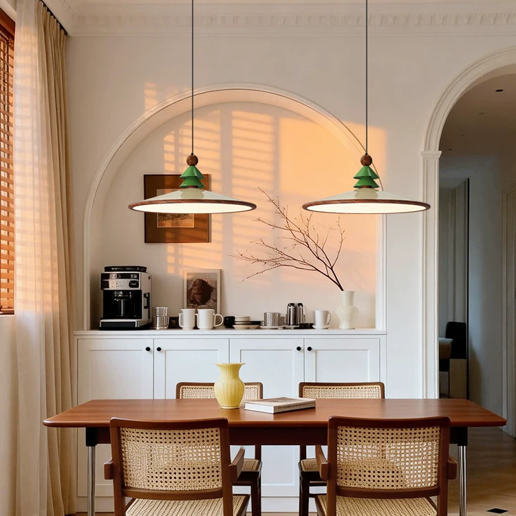 Pair of pine cone pendant lights with green shades and brass ring diffusers.
