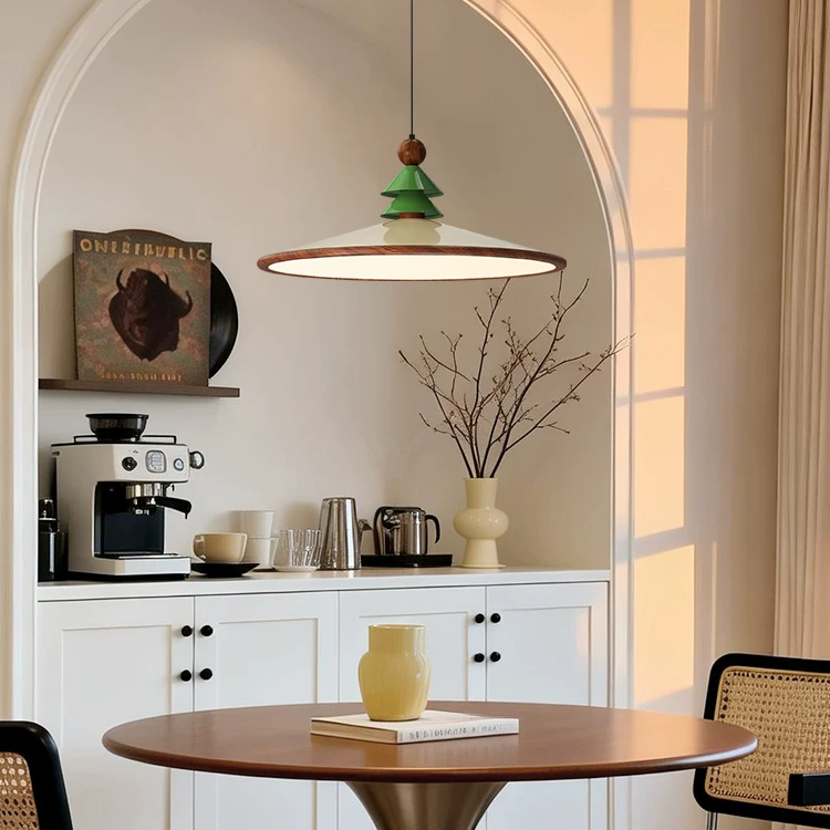 Green pine-topped cone pendant light with brass ring diffuser and brown finial detail.