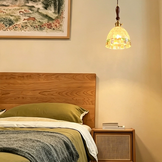 Antique brass mini pendant light with mosaic glass shade above bedside