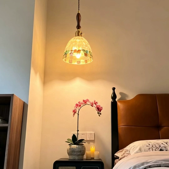 Mini pendant light with mosaic glass shade and warm glow from hanging cord