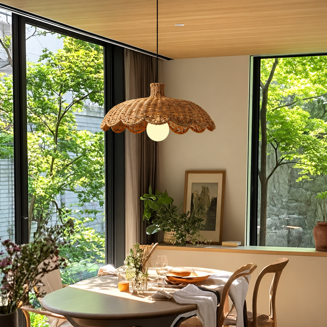 Caleta woven rattan pendant light hanging over dining area with lit bulb