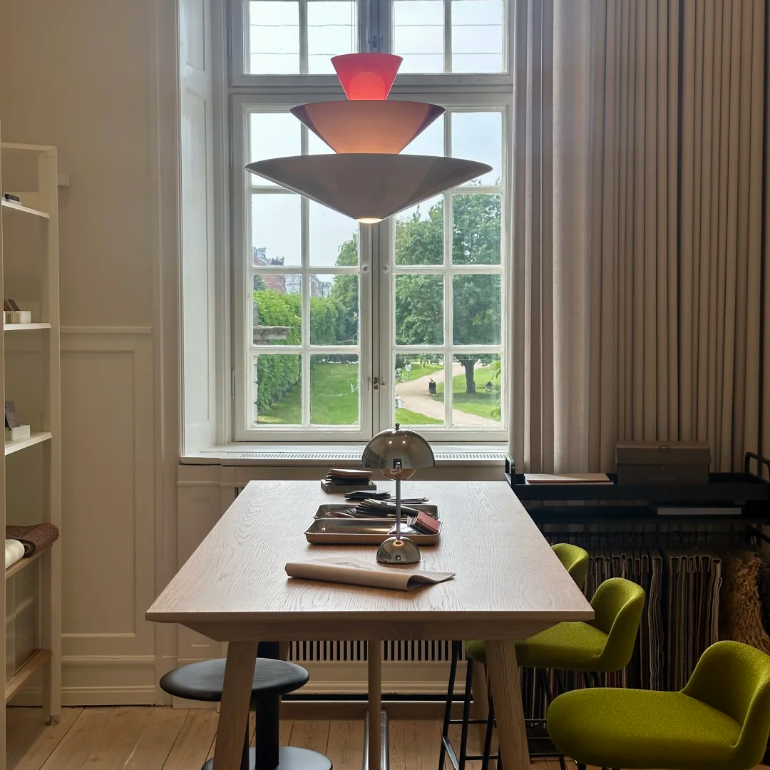 Tiered geometric cone pendant light with red top cone and warm glowing tiers