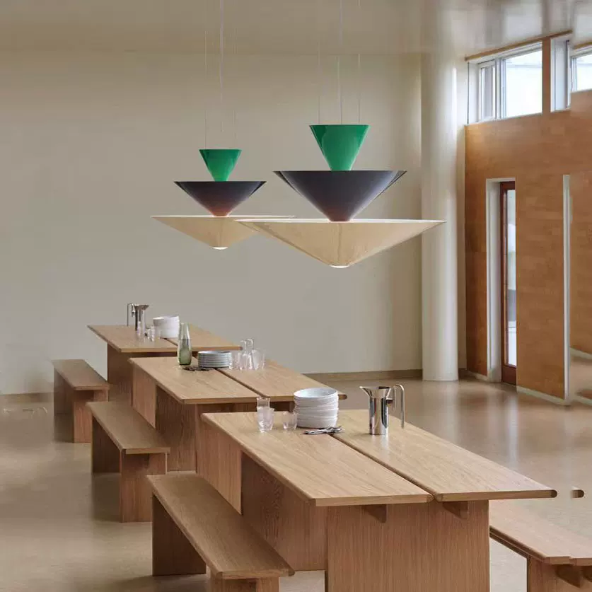 Green tiered cone pendant light with three stacked shades over a dining table