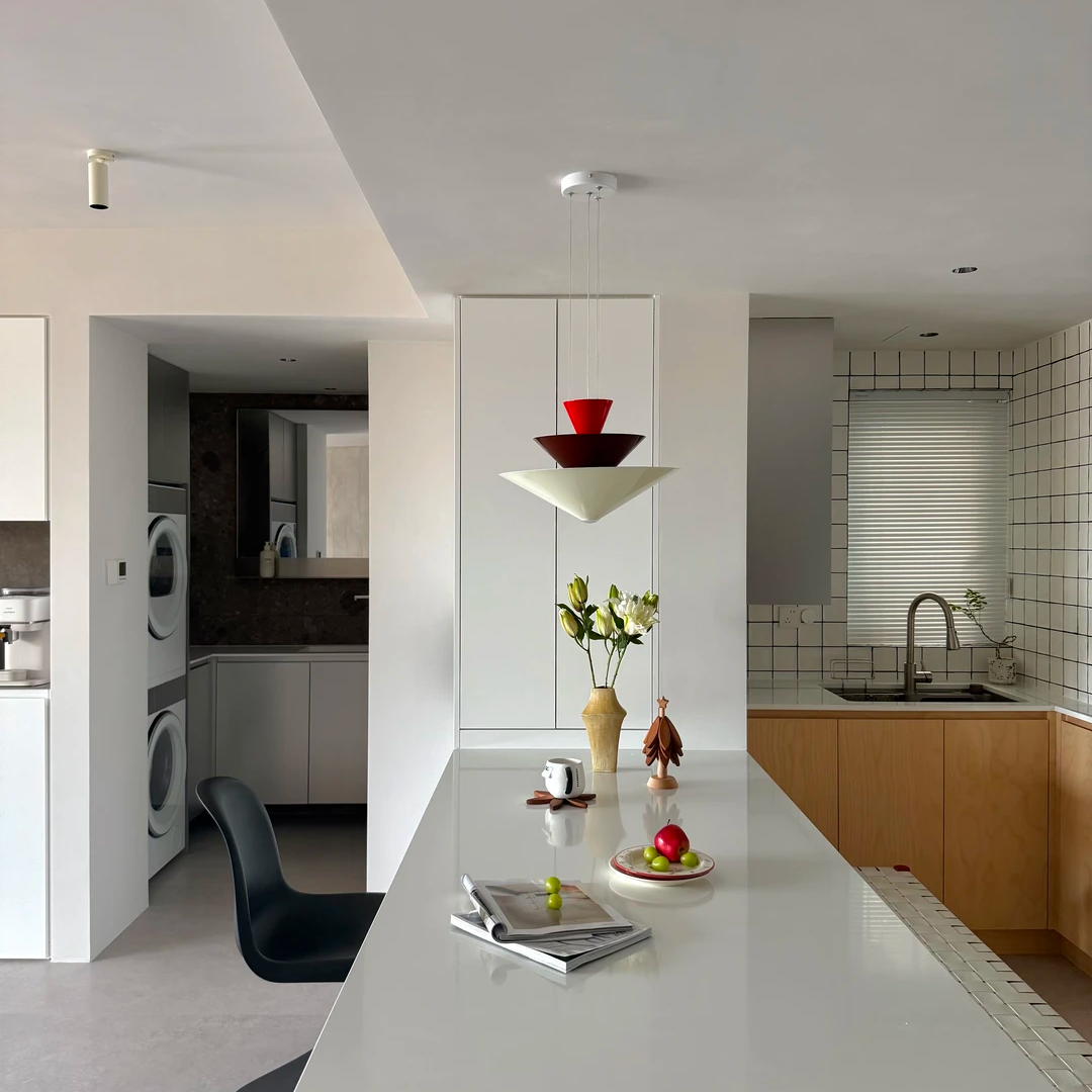 Red tiered cone pendant light with three stacked shades above a kitchen island