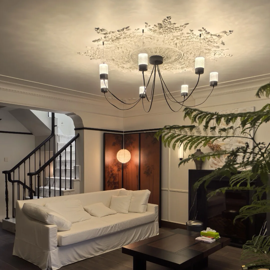 Black catenary drape chandelier with multiple cylindrical fabric shades on curved metal arms