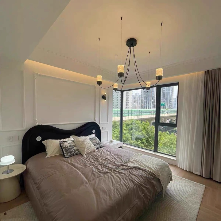 Catenary drape chandelier with central black canopy and curved suspension cords, fabric cylinders