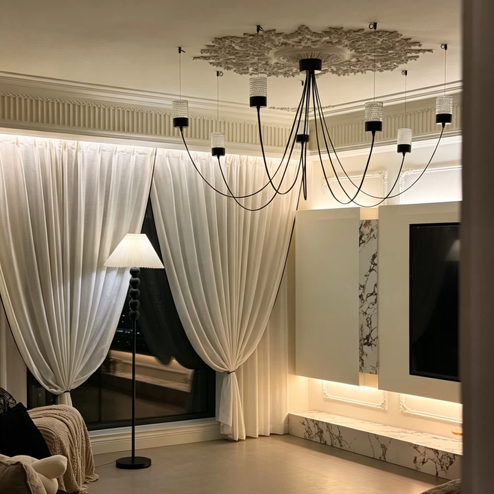 Catenary sculptural chandelier with black canopy, arched cords, and multiple fabric cylinder shades