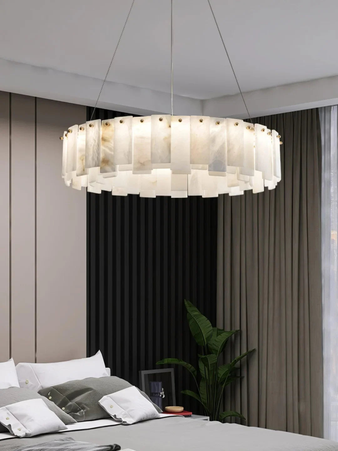 Oslo alabaster disc chandelier hanging above a bed, showing layered alabaster shade panels
