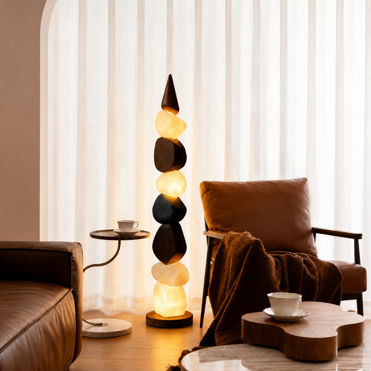 Pebble-style floor lamp with stacked illuminated stones and dark round base