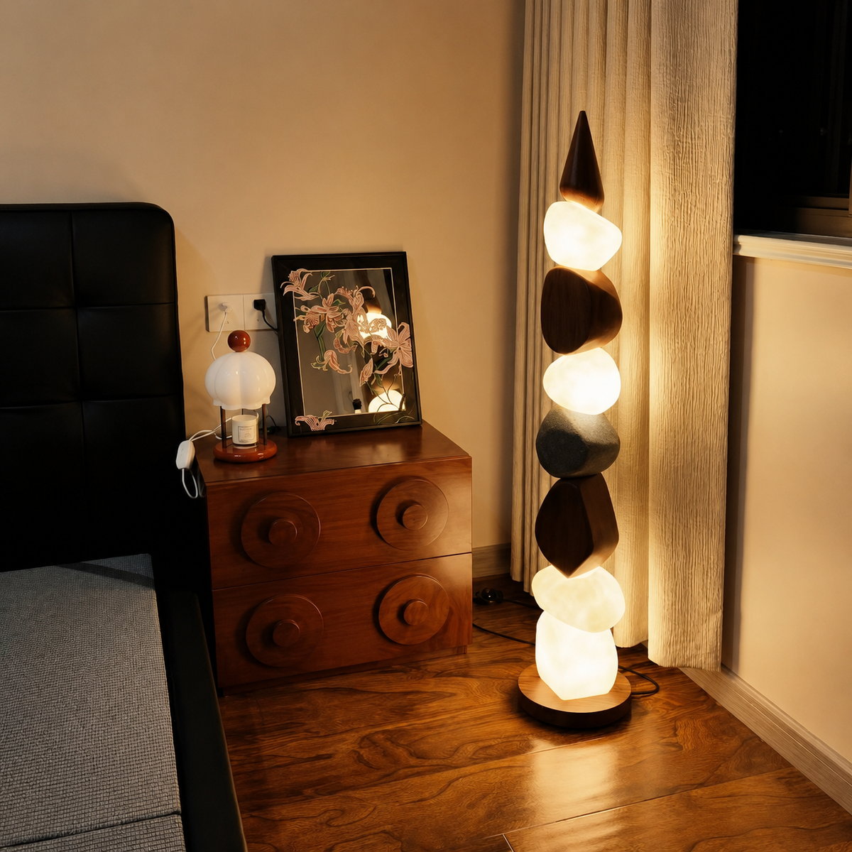 Stacked pebble floor lamp with illuminated stone shapes and round wooden foot
