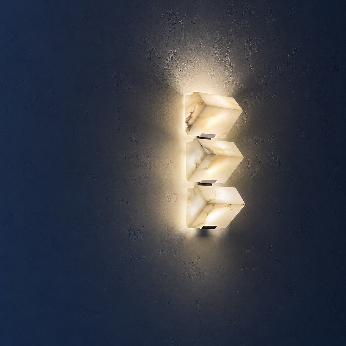 Triple alabaster cube wall sconce with glowing stacked alabaster shades