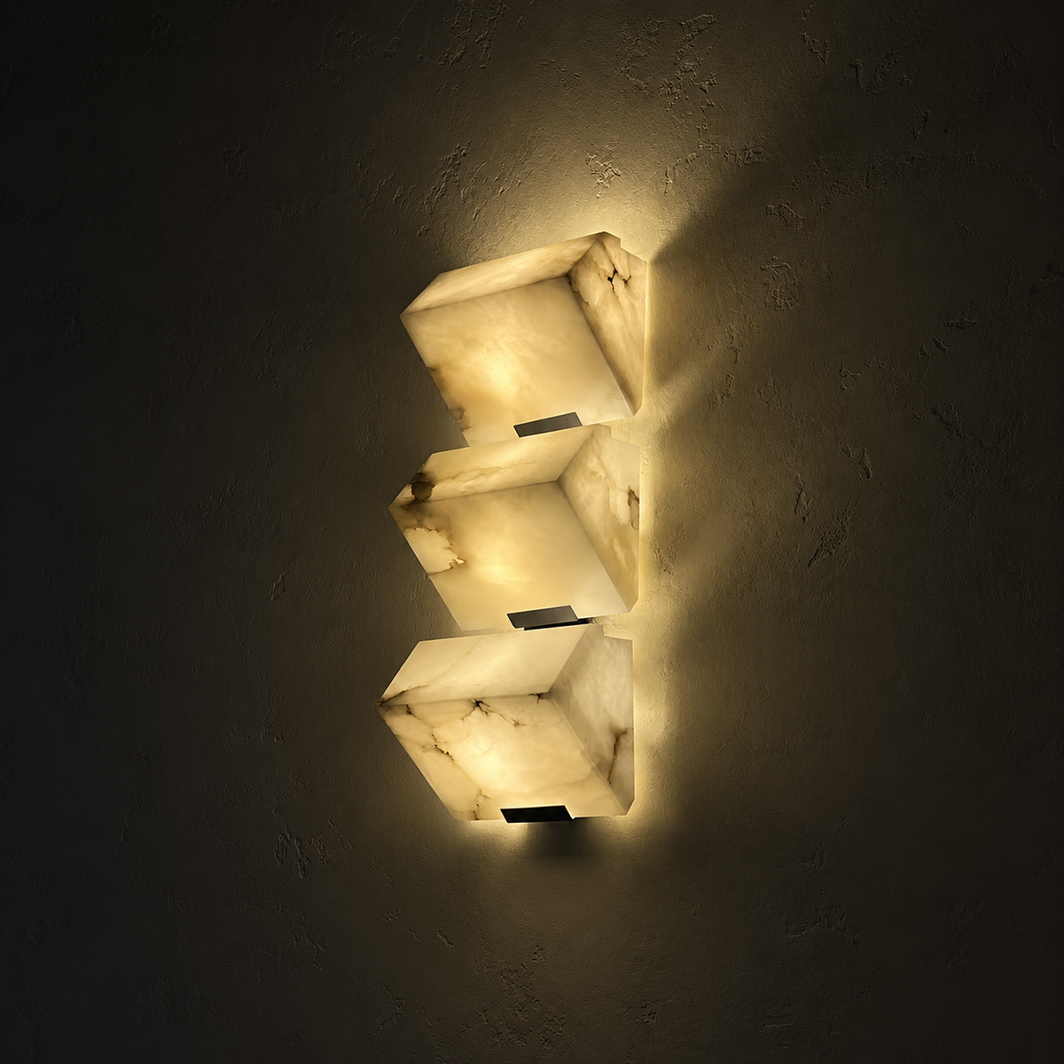 Triple alabaster cube wall sconce with three glowing stacked shades
