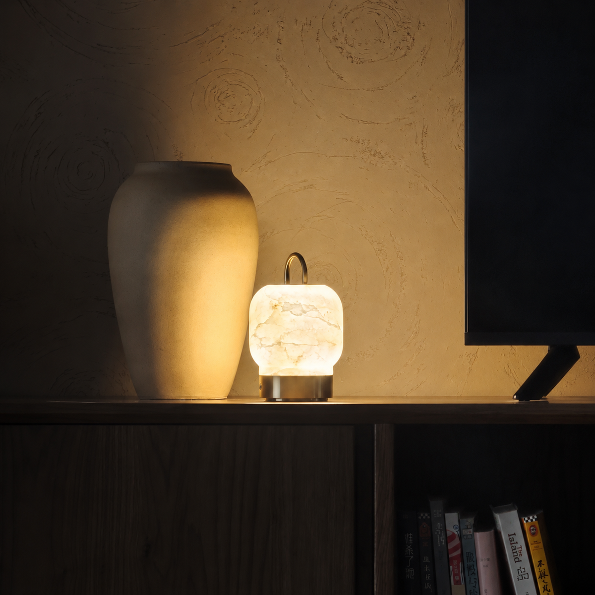 Cordless table lamp with glowing cream alabaster shade and brass base, arched handle
