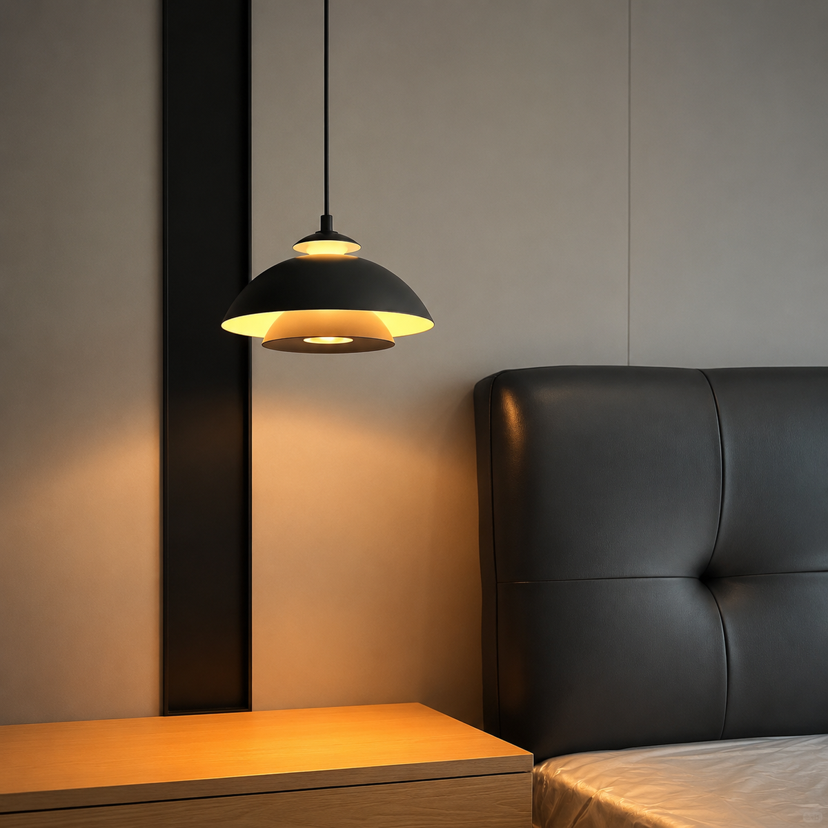 Black dome pendant light hanging over a couch, casting warm light.